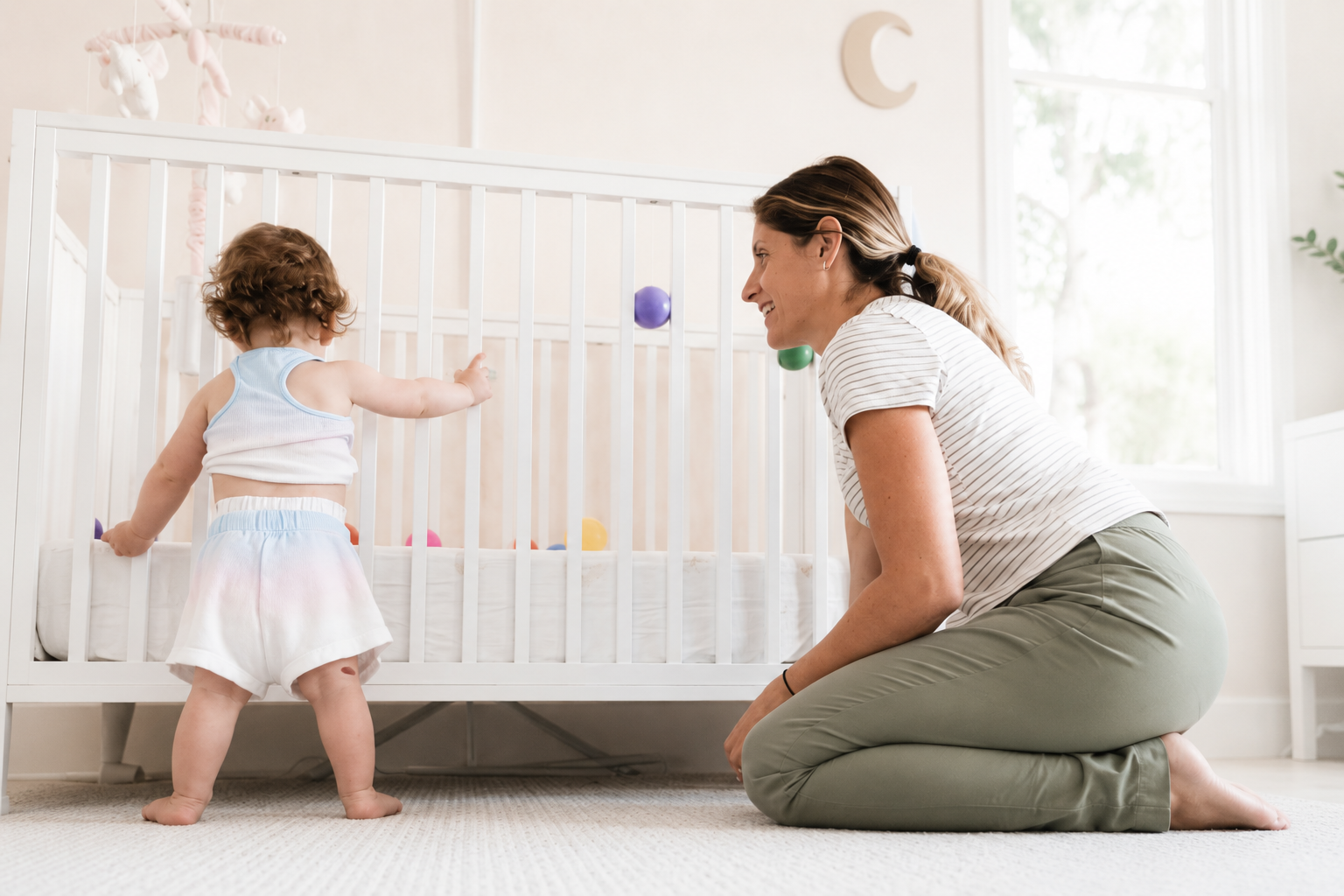 Pediatric therapist supporting a toddler in a bright home