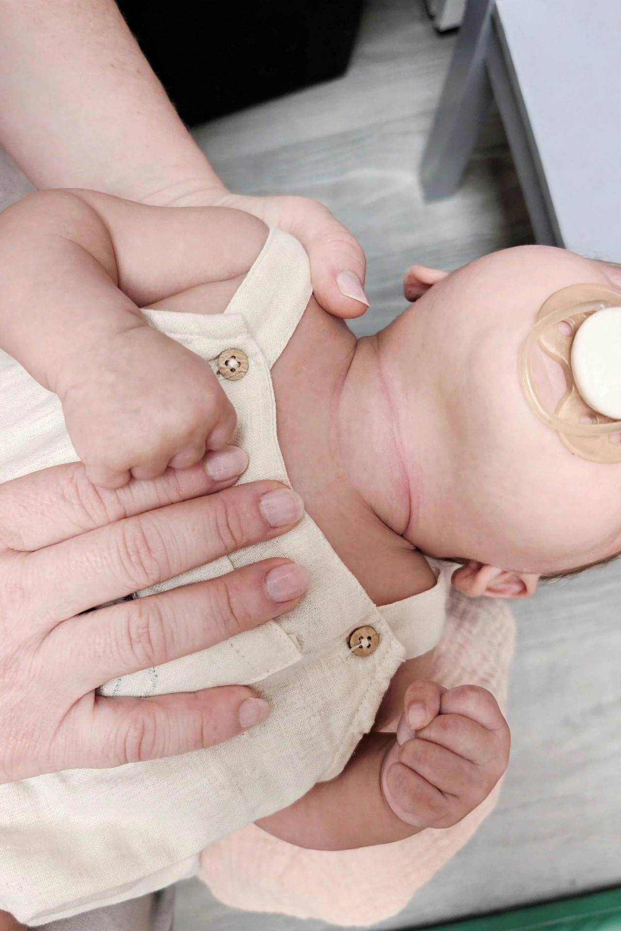 Baby's fisted hands, a sign of held tension