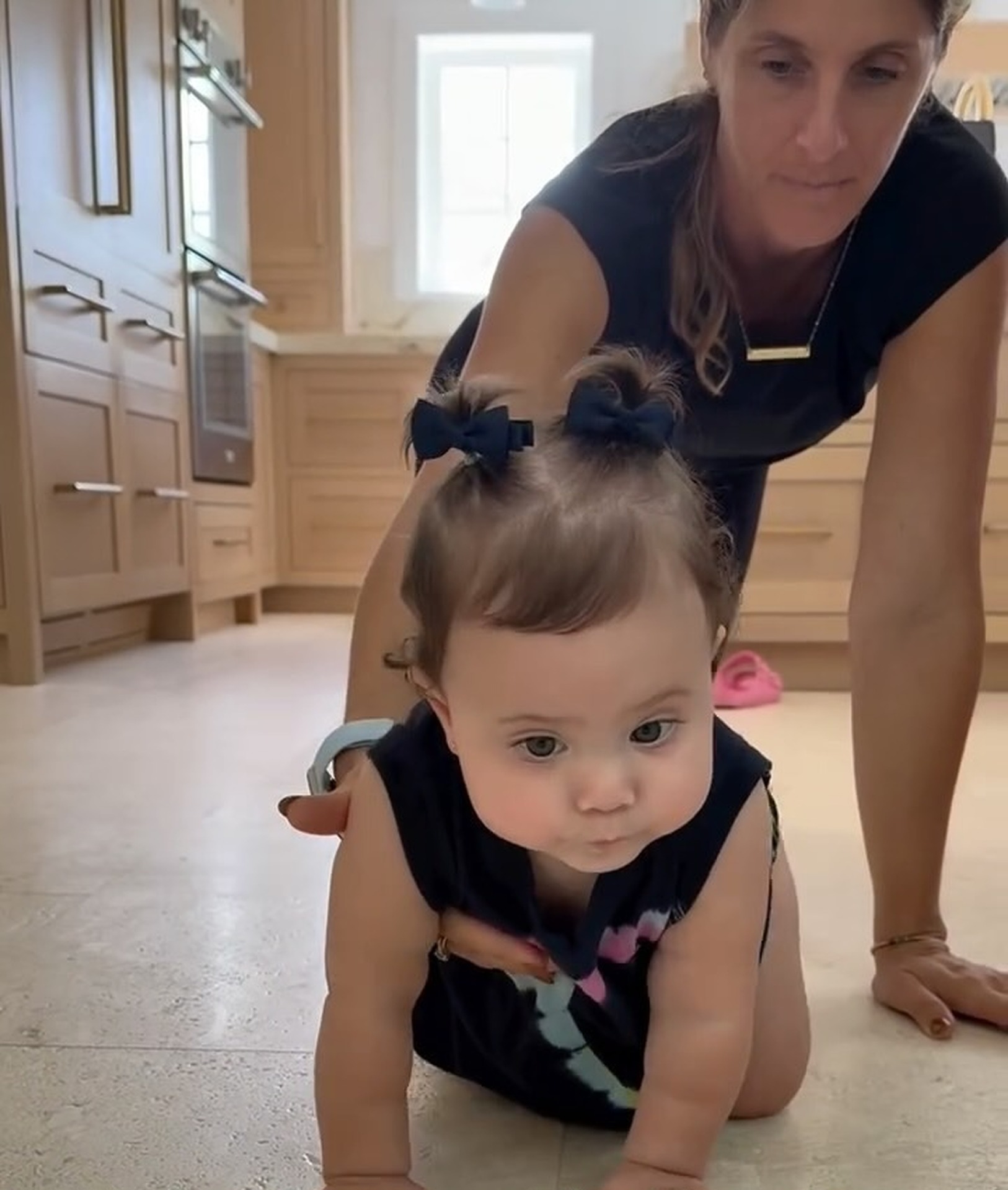 Toddler on hands and knees with therapist guiding crawling